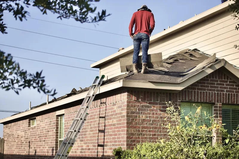 Professional roofer working on a residential roof in Center